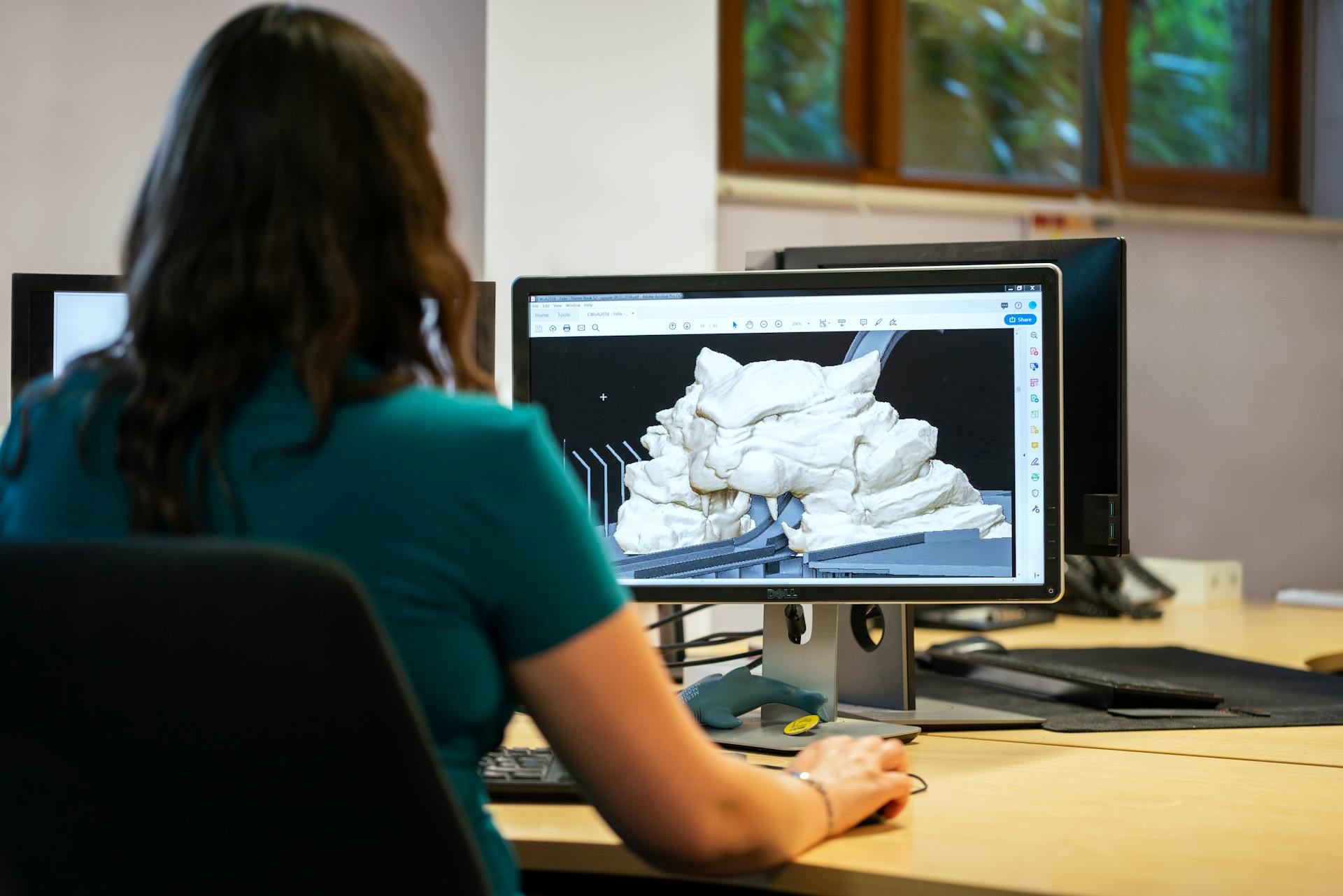 pexels-thisisengineering-3862372 Een ontwerper die met een klant samenwerkt aan een 3D model voor een printproject, met technische tekeningen en een computer